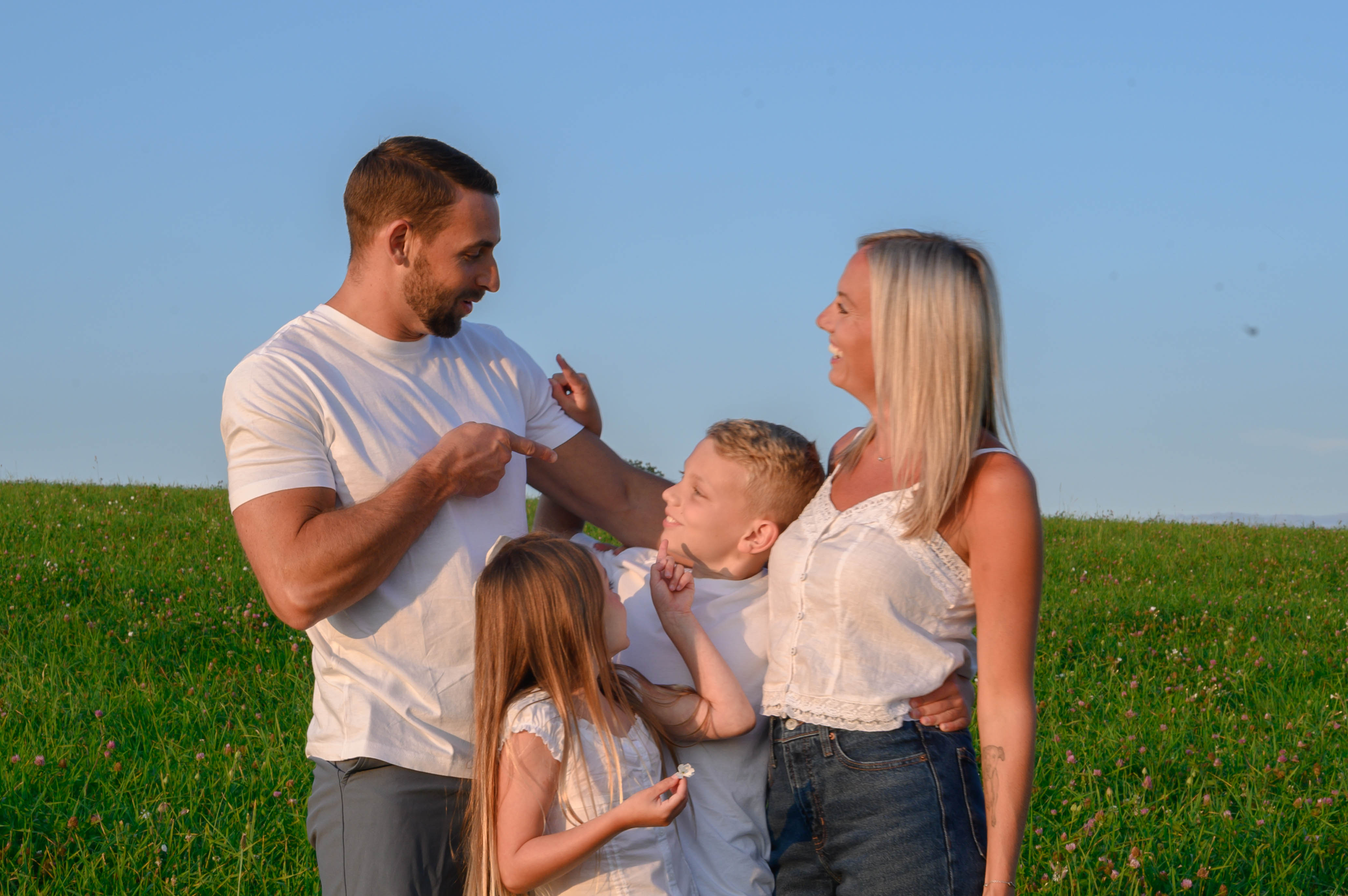 A family smiling and pointing at eachother